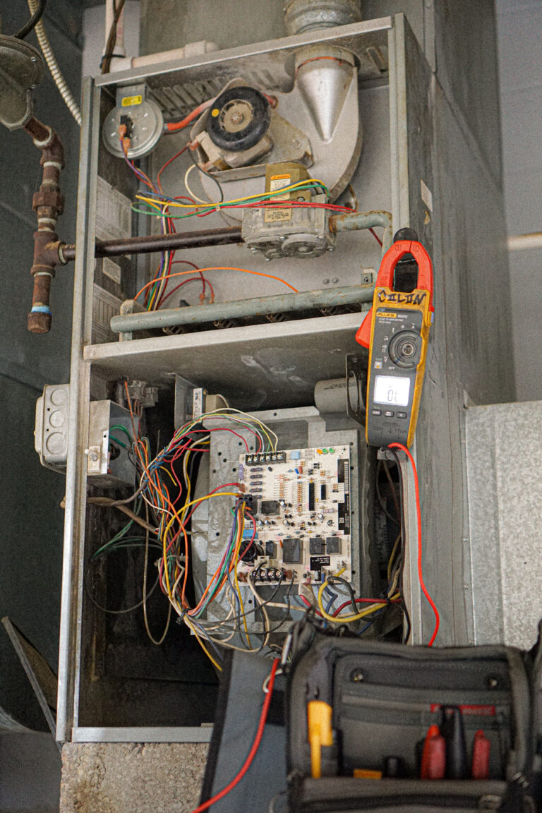 Technician testing electrical components inside a furnace in Millville, NJ, after a reported burning smell