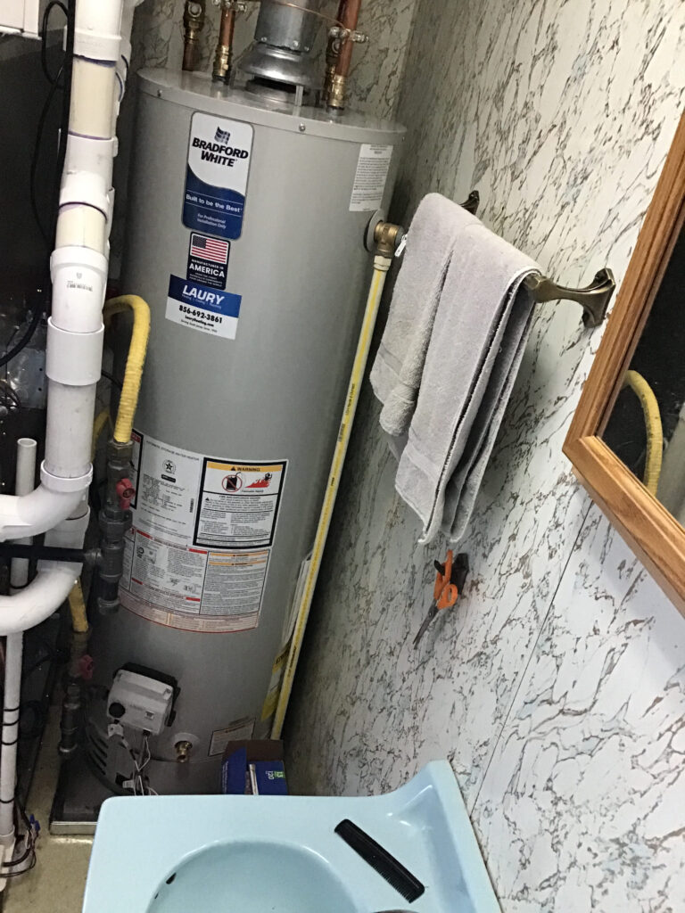 Hot water heater installed in a tight utility space with proper clearance and venting