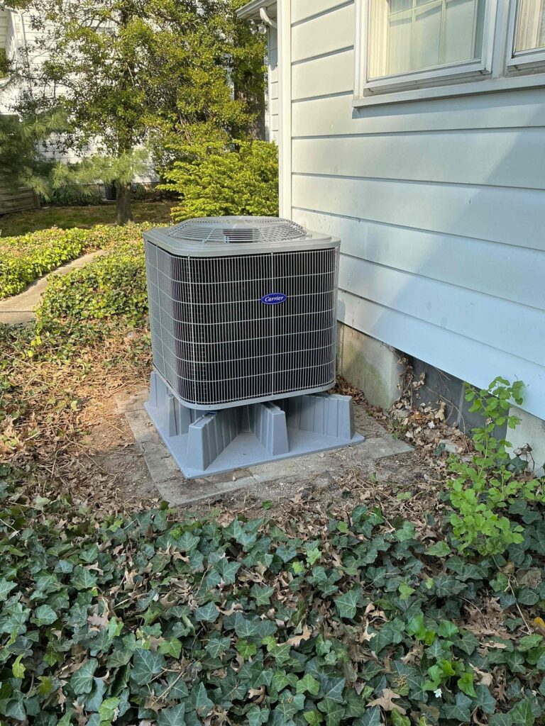 Laury Heating outdoor heat pump installed beside a home