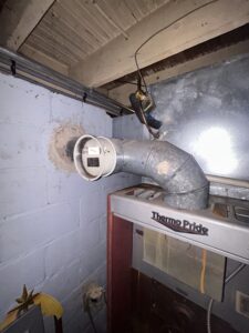 Vent pipe above an older Thermo Pride oil furnace