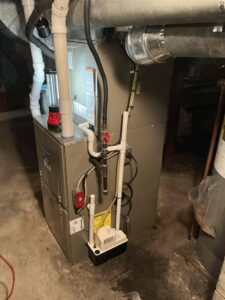 Carrier gas furnace and evaporator coil installed in a Buena basement, with PVC venting and a condensate pump.