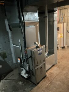 Carrier gas furnace in the basement with ductwork, PVC venting, and a condensate pump