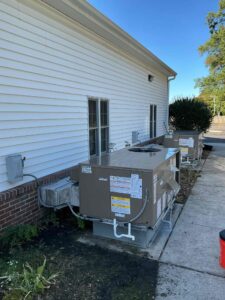 Two new packaged HVAC units beside Richwood United Methodist Church with duct connections through the exterior wall
