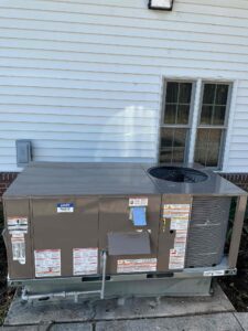 New gas/electric packaged HVAC unit with a Laury Heating service label outside the church