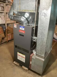 New Airtemp oil furnace with connected ductwork and vent pipe in a Rostan Court basement in Vineland, NJ.
